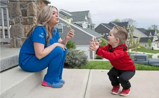  ?? Emily Matthews/Post-Gazette photos ?? Tiffany DuMont, a pulmonary specialist, blows bubbles with her son Zachary Flanigan, 2, outside their home in Ohio Township.