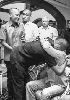  ??  ?? Najib (right) watches as Jumadil (second right), Mohd Ridzuan (left) and Fandi (second left) are reunited with their families at the PM’s official residence. — Bernama photo