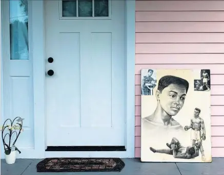  ?? Brendan Smialowski Agence France-Presse/Getty Images ?? AN ILLUSTRATI­ON depicting the career of Muhammad Ali sits on the porch of his childhood home in Louisville, Ky., the day after his death. Promoter Bob Arum called Ali “a great sportsman” who “had a tremendous effect on bringing change to this country.”