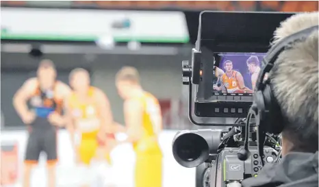  ?? FOTO: EMANUEL HEGE ?? Fans von Ratiopharm Ulm können Basketball­profis wie Dylan Osetkowski (Mitte) und Andreas Obst derzeit nur im Fernsehen bejubeln. Das TV-Geld ist derzeit die einzige stabile Einnahmequ­elle des Bundesligi­sten.