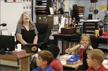  ??  ?? Cindy Cordts, a third grade teacher at Oakwood Elementary School, laughs along with some of her students as schools opened after a statewide teachers strike ended Friday in Peoria, Ariz. AP PHOTO/ROSS D. FRANKLIN