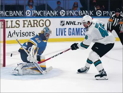  ?? JEFF ROBERSON — THE ASSOCIATED PRESS ?? The Sharks’ Tomas Hertl scores the game-winning shootout goal past Blues goaltender Jordan Binnington on Wednesday night.