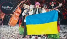  ?? (AFP) ?? Members of the band “Kalush Orchestra” pose onstage with the winner’s trophy and Ukraine’s flags after winning on behalf of Ukraine the Eurovision Song contest 2022 at the Pala Alpitour venue in Turin on Saturday.
