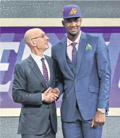  ??  ?? Deandre Ayton, right, poses with NBA commission­er Adam Silver after the Phoenix Suns selected him as the first pick.