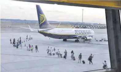  ?? ÁNGEL DE CASTRO ?? Varios pasajeros se dirigen a un avión de Ryanair en el Aeropuerto de Zaragoza.