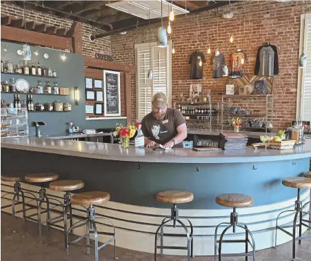  ?? Pittsburgh Post-gazette Photos ?? SPIRITED ADVENTURE: Catoctin Creek Distillery in Purcellvil­le, Va., is housed in a former car dealership, above, and offers a variety of tasting flights, top right. A sign, below, points the way to more stops on the trail