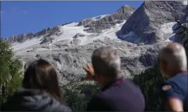  ?? LUCA BRUNO — THE ASSOCIATED PRESS ?? Two police officers, right, show a journalist the Punta Rocca glacier near Canazei in the Alps in northern Italy on Monday, a day after a huge chunk of the glacier broke loose, sending an avalanche of ice, snow and rocks onto hikers.