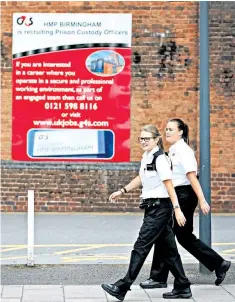  ??  ?? G4S prison officers walk past HMP Birmingham in Winson Green, above