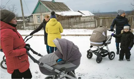  ?? LYNSEY ADDARIO/THE NEW YORK TIMES ?? Ukrainian mothers and their babies wait to receive medical checkups from a mobile clinic on Jan. 31 in Levkivka, Ukraine.