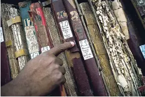  ?? AP PHOTO ?? This January 12, 2017, photo shows a man searching among volumes labelled ‘Whites’ as part of an effort to digitise colonial-era registries of blacks and whites at the Espiritú Santo Church in Old Havana, Cuba. MORE TRAVEL CHOICES