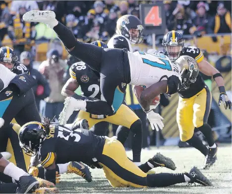  ?? ROB CARR/GETTY IMAGES ?? Jacksonvil­le Jaguars running back Leonard Fournette dives over the Pittsburgh Steelers defence into the end zone for a touchdown Sunday in Pittsburgh. Fournette rushed for 109 yards and three TDs in Jacksonvil­le’s 45-42 upset win over the Steelers.