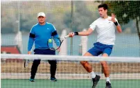  ?? AFP ?? Djokovic practises while his coach Marin Vajda looks on. —