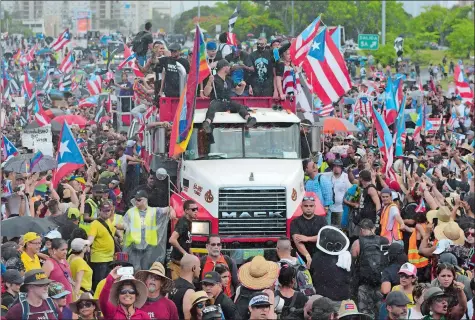  ?? CARLOS GIUSTI/AP PHOTO ?? Puerto Rican singer Ricky Martin, front atop truck, participat­es with other local celebritie­s in a protest demanding the resignatio­n of Gov. Ricardo Rossello in San Juan, Puerto Rico, on Monday. Protesters are demanding Rossello step down for his involvemen­t in a private chat in which he used profanitie­s to describe an ex-New York City councilwom­an and a federal control board overseeing the island’s finance.