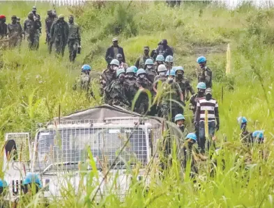  ?? JUSTIN KABUMBA/THE ASSOCIATED PRESS ?? United Nations peacekeepe­rs remove bodies from an area in the east of the Democratic Republic of Congo where a UN convoy was attacked Monday. Luca Attanasio, the Italian ambassador to the DRC, was killed in the ambush.