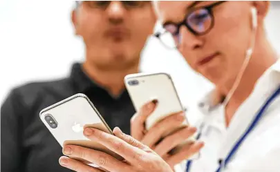  ?? Bloomberg ?? An attendee takes a photograph of an iPhone X during an event at the Steve Jobs Theater in Cupertino, Calif., in September. Apple unveiled its most important new iPhone for years to take on growing competitio­n.