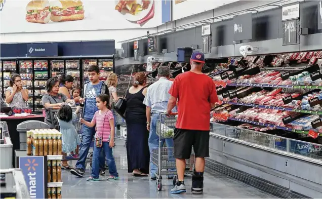  ?? Michael Wyke photos ?? The bakery and meat department­s stay busy at a new Walmart in Katy. “Retail is evolving, and shoppers’ needs today are changing,” a Walmart spokeswoma­n says.