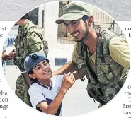  ??  ?? RELIEF Child greets smiling Turkish soldier