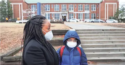  ?? JOE RONDONE/THE COMMERCIAL APPEAL ?? Jeremiah Payne, 9, and his grandmothe­r Stacie Glover stand outside Vollintine Evergreen Neighborho­od School on March 1. Shelby County Schools will continue requiring students and staff to wear masks, regardless of vaccinatio­n status.
