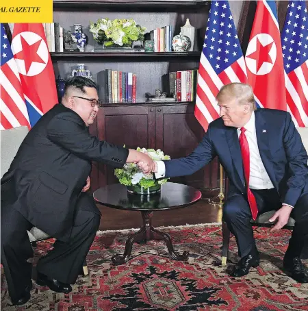  ?? SAUL LOEB/AFP/GETTY IMAGES ?? U.S. President Donald Trump shakes hands with North Korean leader Kim Jong Un as they sit down for their historic meeting at the Capella Hotel in Singapore on Tuesday, the first time the leaders of the two countries have met for a summit.