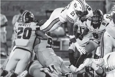  ?? THE ASSOCIATED PRESS ?? Auburn running back Kerryon Johnson, top, leaps over a pile of Missouri defenders to score a touchdown Saturday in Columbia, Mo. The Tigers play No. 24 Mississipp­i State on Saturday.