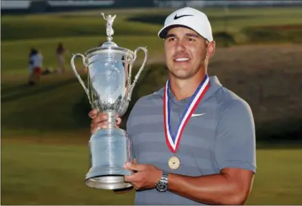  ?? CAROLYN KASTER — THE ASSOCIATED PRESS ?? Brooks Koepka holds up the Golf Champion Trophy after winning the U.S. Open Golf Championsh­ip, Sunday in Southampto­n, N.Y.