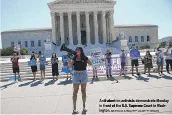  ?? NICHOLAS KAMM/AFP VIA GETTY IMAGES ?? Anti-abortion activists demonstrat­e Monday in front of the U.S. Supreme Court in Washington.