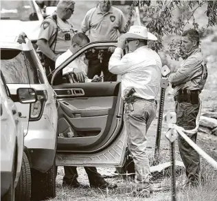  ?? Bob Owen / Staff photograph­er ?? A Texas Ranger, right, talks with Comal County Sheriff ’s deputies Thursday at the scene where another sheriff ’s deputy was shot in the arm while serving an arrest warrant.