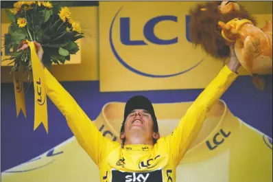  ?? The Associated Press ?? GOLDEN OPPORTUNIT­Y: Geraint Thomas, wearing the overall leader’s yellow jersey, celebrates Saturday on the podium after the Tour de France’s 20th stage, an individual time trial over 19.3 miles from Saint-Pee-sur-Nivelle to Espelette, France. His time on Saturday may have sealed his first Tour de France title.