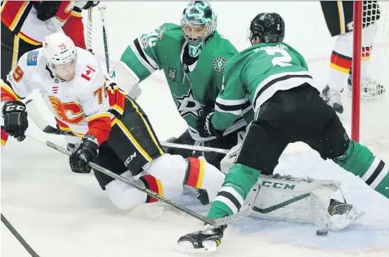  ?? LM OTERO/ THE ASSOCIATE PRESS ?? Flames winger Micheal Ferland is knocked to the ice in front of Stars goalie Ben Bishop on Friday night in Dallas. Tyler Seguin’s hat trick paced the Stars to a 6- 4 win while Bishop made 34 saves in the game.