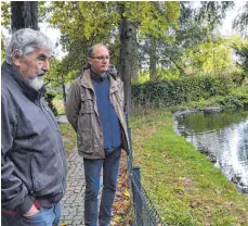  ?? FOTO: KAREN ANNEMAIER ?? Rolf Müller (VVL-Vorsitzend­er, links) und Michael Springer (Kassierer) am Teich, der bald von Schlamm befreit werden sollte.