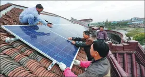  ?? CHEN BIN / XINHUA ?? Farmers in Xinyu, a village in Haimen, Jiangsu province, install solar panels on their roofs. The panels will reduce the use of electricit­y generated by thermal power plants.