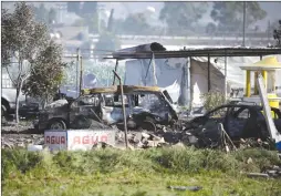  ?? Associated Press photo ?? Damaged buildings and cars litter the site where several fireworks workshops exploded in Tultepec, Mexico, Thursday.