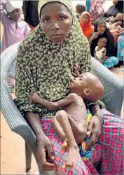  ?? Robyn Dixon Los Angeles Times ?? HADIZA ADAMU holds her 1-year-old son, Hassan. After wandering for days seeking help for him, she found a UNICEF center in Maiduguri, Nigeria.