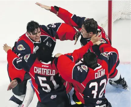  ?? — JASON KRYK/POSTMEDIA NEWS ?? Windsor goaltender Michael DiPietro, left, is mobbed by his teammates after the Spitfires defeated the Erie Otters to win the Memorial Cup on Sunday night.