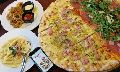  ?? —PHOTOS BY PAMPASTOR ?? The 21-inch XXL pizza in half Prosciutto Crudo di Parma and half Bacon Miele, Calamari Fritti and Carbonara