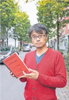  ?? FOTO: HANS-JÜRGEN BAUER ?? Chikara Fujiwara hält sein „Adventure Book“in den Händen. Damit soll der Leser neue Seiten von Düsseldorf entdecken.