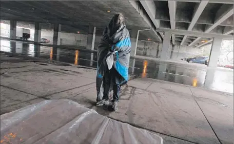  ?? Luis Sinco
Los Angeles Times ?? ADVOCATES say $100 million in annual funding is the minimum needed to end homelessne­ss in Los Angeles. Above, a homeless man who declined to be identified takes shelter beneath the 405 Freeway along Venice Boulevard during wet, stormy weather this week.