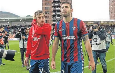  ?? JAJUAN HERRERO / EFE ?? Javi Lara y Raúl Navas, jugadores del Eibar, abandonan decepciona­dos Ipurua