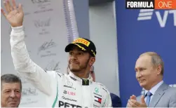  ?? AP ?? Mercedes driver Lewis Hamilton ( centre) of Britain celebrates winning while Russian President Vladimir Putin ( right) applauds after the Russian Formula One Grand Prix at the Sochi Autodrom circuit in Sochi, Russia, on Sunday. —