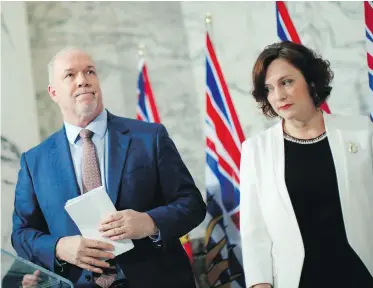  ?? CHAD HIPOLITO, THE CANADIAN PRESS ?? Premier John Horgan and Minister of Energy Michelle Mungall appeared unhappy about approving the Site C dam project at a press conference in Victoria on Monday.