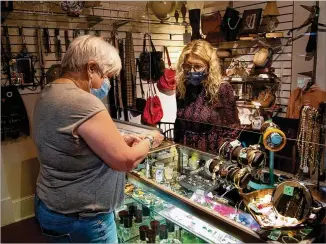  ?? PHOTOS BY STEVE SCHAEFER FOR THE AJC ?? Karen Moore ( right), one of the offifficer­s at the Giving Tree Thrift Store in Chamblee, helps Karyl Boyd with a purchase. Moore’s store helps those with special needs.