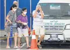  ?? REUTERS ?? Family members of a Batang Kali landslide victim leave Sungai Buloh Hospital’s mortuary on Saturday.