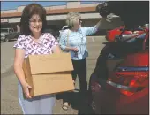  ?? BEA AHBECK/NEWS-SENTINEL ?? Pam Schweitzer, with her mom, Cora Schweitzer, right, carries donations for pets into Coutry Clippers in Lockeford on Friday.