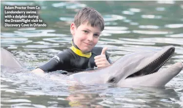  ??  ?? Adam Proctor from Co Londonderr­y swims with a dolphin during the Dreamfligh­t visit to Discovery Cove in Orlando