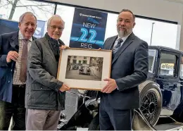  ?? ?? Tom Cummings presented Brian with a framed picture of the Cadet taken during the production of the advert, watched by Roy Upperton.