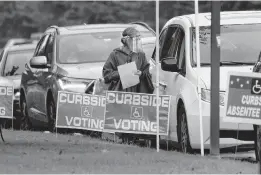  ?? L. TODD SPENCER/STAFF ?? Voters pull up in front of Building 14 at the Municipal Center, in Virginia Beach for early curbside handicappe­d voting on Sept. 18.