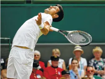  ?? THE ASSOCIATED PRESS ?? Novak Djokovic serves to Martin Klizan during their match Tuesday at Wimbledon. Djokovic led 6-3, 2-0 when Klizan retired with an injured left leg that has bothered him for months.