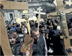 ?? MENAHEM KAHANA/GETTY IMAGES ?? Christian pilgrims carry wooden crosses along the path where Jesus walked, known as the Via Dolorosaon Good Friday in Jerusalem’s Old City. A young tourist was killed in a knife attack aboard a light rail line in the city.