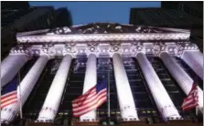  ?? MARK LENNIHAN — THE ASSOCIATED PRESS FILE ?? In this file photo, American flags fly in front of the New York Stock Exchange. European shares rose on Monday despite a poor start for the week in Asia, where the Tokyo benchmark fell more than 3 percent as investors registered their disappoint­ment...