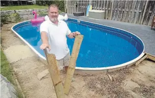  ?? DAVID BEBEE WATERLOO REGION RECORD ?? Mark Stapleton holds deck boards gnawed by rats. He has been tearing out a pool deck in the backyard of his Waterloo home to try and get rid of them.